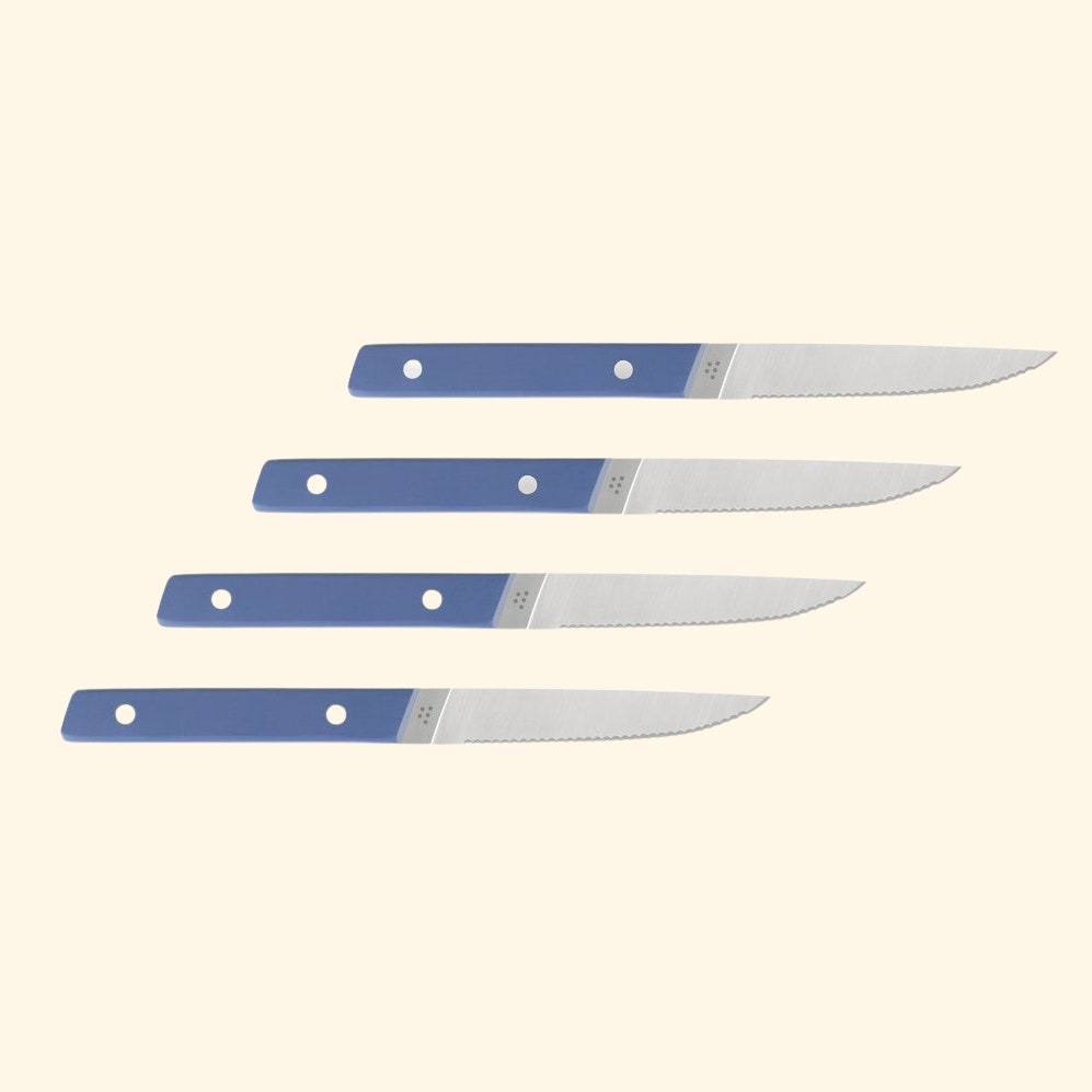 Four Misen steak knives on colored background
